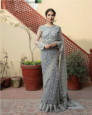Description: An enchanting ensemble Almas features a heavy embellished net saree. This luxurious ensemble is adorned with shimmery thread and zardozi work, blended with crystals and Sitara work. It is enhanced with heavier work Pallu and borders. It is a saree...