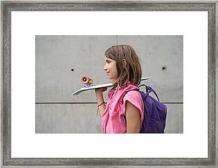 Teenage Girl Carrying Skateboard On Shoulder Outdoors Framed Print
