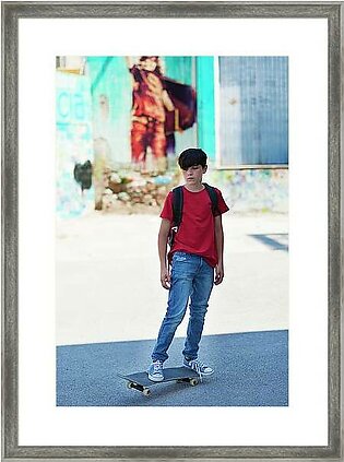 Full Length Of Student Skateboarding On Road In City Framed Print
