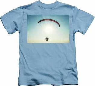 Paraglider in the air, beautiful blue sky in the background. Kids T-Shirt