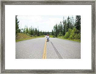 Rear View Of Young Boy Biking On Balance Bike. Framed Print